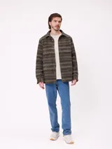 Camisa de manga larga con diseño de estampado étnico en tonos azules y beige. Presenta cuello clásico, cierre frontal con botones y bolsillos en el pecho.