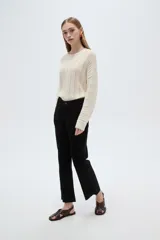 Pantalón jean negro de tiro medio y corte flare, con bolsillos laterales y traseros.