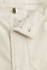 Pantalón de tiro alto confeccionado en pana de algodón, con diseño acampanado, bolsillos de parche frontales y pliegues marcados en el frente y la espalda.