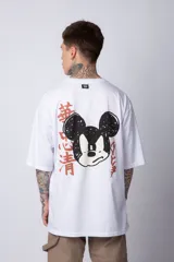 Remera negra de algodón de corte oversize, con mangas cortas y cuello redondo. Estampado pequeño en el frente y diseño grande en la espalda con Mickey Mouse y caracteres orientales en tonos rojizos.