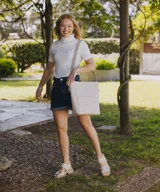 Sandalias de cuero color crudo con dos tiras horizontales en el empeine, una de cuero liso y otra con detalle dorado. Suela track color beige.