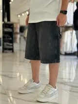 Bermuda de jean estilo carpintero, color celeste, con bolsillos laterales amplios, presilla para herramientas y diseño amplio de corte oversize.