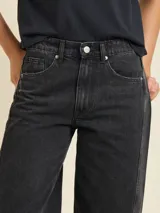 Jean de corte balloon fit, confeccionado en denim de algodón en tono azul claro lavado. Presenta un diseño de tiro medio con costuras laterales curvadas que definen su silueta amplia y relajada.
