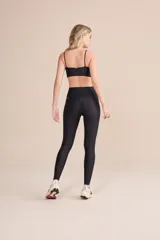 Calza deportiva de tiro alto con diseño de alta compresión y textura acanalada con leve brillo. Cuenta con un bolsillo trasero en la cintura y tecnología de ajuste adaptable.