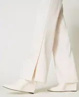 Pantalón de vestir color crudo, de corte recto, con pretina, botón y abertura en el ruedo. Marca Twinset.