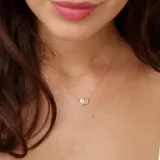 Collar dorado con cadena fina y dije de dos cristales transparentes: uno rectangular y otro en forma de lágrima.