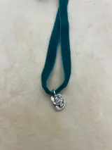 Gargantilla de terciopelo con dije plateado con forma de paloma.