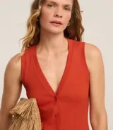 Blusa estilo chaleco, confeccionada en ribana negra, con abotonado delantero, sin mangas y con textura acanalada.