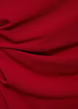 Vestido largo de fiesta color rojo, con escote asimétrico y diseño drapeado.