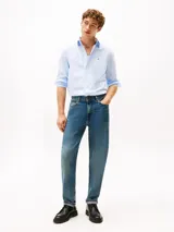 Camisa de popelín de algodón celeste con sutiles rayas verticales blancas, de corte regular, manga larga y cuello camisero con botones. Presenta cierre frontal con botones y el logo bordado de Tommy Hilfiger en el pecho.