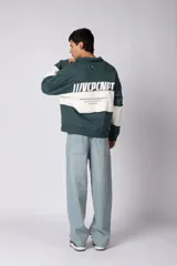 Buzo tipo polo de calce relajado con diseño de bloques de color en tonos marrón y blanco. Presenta cuello polo, cierre frontal parcial y logo estampado en el pecho. Confeccionado en tejido pesado con estructura.
