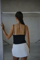 Top negro con escote en V profundo y detalles de encaje floral en el busto, con breteles finos.