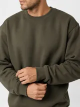 Buzo de cuello redondo color verde militar, de mangas largas con puños y dobladillo acanalados, y calce holgado.