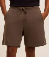 Bermuda masculina de algodón con felpa, color negro, corte slim fit. Presenta cintura elástica con cordón ajustable, bolsillos y etiqueta aplicada.