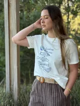 Pantalón de lino marrón con rayas verticales blancas, corte recto, cintura con elástico ancho y cinturón de rafia extraíble.