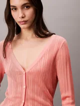 Sweater tipo cardigan de Calvin Klein, confeccionado en tejido de canalé de viscosa con un ligero brillo. Presenta un corte clásico, cuello en V, cierre frontal con botones y mangas largas.