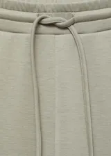 Pantalón wide leg de tiro medio con cintura elástica y cordón ajustable. Presenta diseño con pinzas frontales, bolsillos laterales y corte holgado.