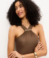 Malla enteriza marrón con escote halter cruzado y detalle metálico dorado en el frente.