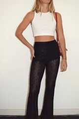 Pantalón de encaje negro con corte acampanado y cintura elástica.