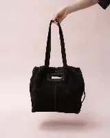 Cartera tipo tote de cuero color bordó, con diseño fruncido en los laterales y abertura central tipo asa. Presenta una silueta flexible y espaciosa, ideal para uso diario.