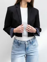 Blazer crop negro, marca Dictionary, con cuello con solapa y manga larga. Tiene forro interno estampado a rayas.