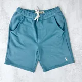 Short de algodón color celeste con cintura elástica ajustable con cordón y bolsillos laterales.