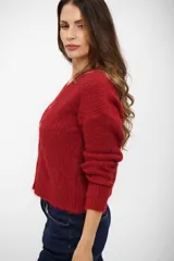 Saco tipo cardigan de punto en color rojo, con escote en V y cierre frontal de botones. Presenta mangas largas y textura suave.