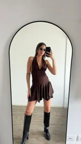 Vestido corto blanco con escote halter y falda con volados.