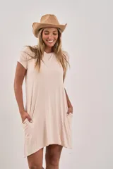 Vestido corto de manga corta, color beige claro, con corte holgado y bolsillos laterales.