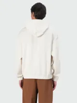 Buzo negro con capucha y cordones ajustables, corte holgado. Presenta un pequeño logo bordado en relieve en el pecho.