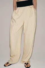 Pantalón de tiro medio Zara Woman Collection, con fajín negro a contraste, pliegues delanteros, pernera ancha, bolsillos laterales ocultos y cierre lateral con cremallera.