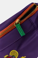 Riñonera violeta con detalles en naranja, perteneciente a la colección especial Fruit of the Loom x Zara. Cuenta con un compartimento principal y un bolsillo frontal con cierre de cremallera metálica, además de un bordado distintivo en la parte inferior. Incorpora un cinturón ajustable con cierre de clip de plástico negro.