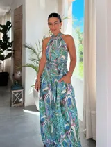 Conjunto de dos piezas compuesto por blusa con cuello halter y pantalón de corte amplio y fluido. Presenta un estampado artístico con motivos orgánicos en tonos azules, verdes y rosados.