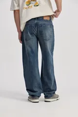 Pantalón jean de corte recto y amplio, color azul con efecto lavado y desgaste sutil.