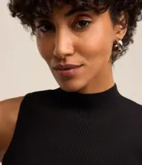 Musculosa roja de punto con cuello alto y tirantes anchos.