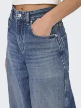 Jean de corte barrel fit con tiro alto y pierna suelta, confeccionado en denim de algodón con lavado azul oscuro y costuras reforzadas.