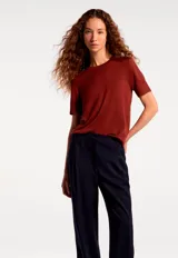 Blusa de manga corta confeccionada en tejido de punto, color negro, con cuello redondo y diseño clásico.