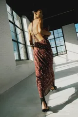 Vestido midi satinado color marrón con estampado de lunares difuminados, de cuello halter con tiras ajustables para atar en la espalda y escote en V.