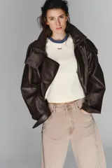 Jeans de tiro medio, color beige rosado con efecto lavado, corte amplio (baggy balloon) y detalle de costuras torcidas en el frente de las piernas.