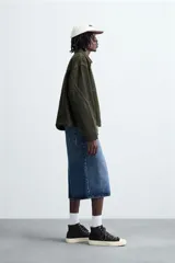 Cazadora de corte relajado confeccionada en tejido de algodón con efecto lavado. Presenta cuello solapa, cierre frontal con cremallera, bolsillos laterales en la cadera y mangas terminadas en puños con botón.