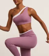 Top deportivo de microfibra color lila con detalle bicolor blanco, hombro único, escote asimétrico y gota vazada.