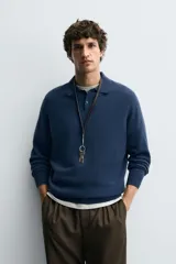 Polo de punto de corte regular fit, confeccionado en una mezcla de lana y cashmere. Presenta cuello solapa con cierre frontal de dos botones, manga larga y terminaciones en rib.