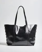 Cartera tote negra de símil cuero con acabado brillante, doble asa de hombro y detalles de tachas metálicas plateadas en los laterales.
