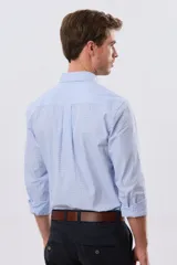Camisa de manga larga con estampa de cuadros pequeños en tonos celeste y blanco, cuello con botones y bolsillo ojal en el pecho con detalle bordado.