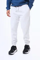 Pantalón de felpa con cintura elástica ajustable mediante cordón, bolsillos laterales y puños acanalados en los tobillos.