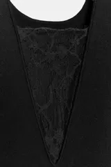 Vestido midi negro, sin mangas, con escote redondo. La parte superior es de tejido liso y la parte inferior es de encaje negro con ruedo asimétrico y deshilachado.