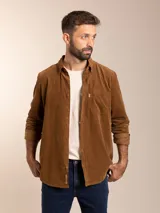 Camisa marrón de pana con cuello abotonado, manga larga con puños abotonados, corte regular fit y bolsillo en el pecho.
