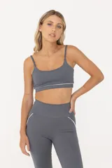 Top deportivo gris con breteles finos regulables y contorno inferior blanco.