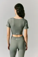 Top deportivo corto color verde militar, de morley sin costuras, con escote en V y mangas cortas.