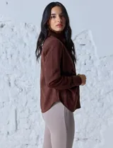 Camisa azul en símil suede, marca Ninety. Cuello con solapa y abertura central con botones. Delantera fruncida.